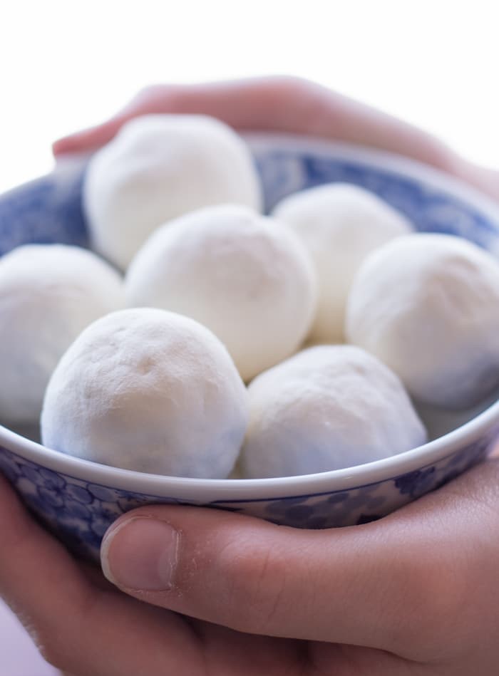 A bowl full of dried curd in hand